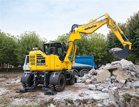 Thematic photo of a Komatsu PW118 wheeled excavator in action