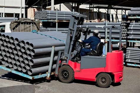 Operator wózka widłowego w ruchu, transportujący ładunki w lakierni proszkowej