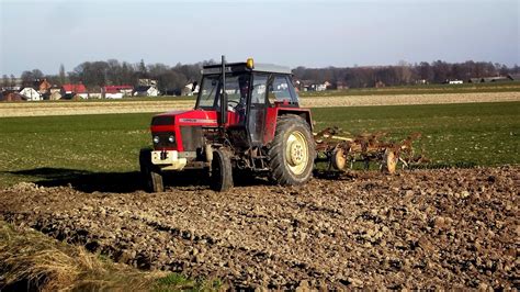 Grafika przedstawiająca traktor Ursus 1222 Turbo z podłączonym pługiem obracalnym, ilustrująca rozkład masy i współpracę podnośnika.
