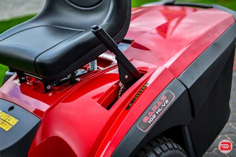 Ilustracja dźwigni centralnej regulacji wysokości koszenia