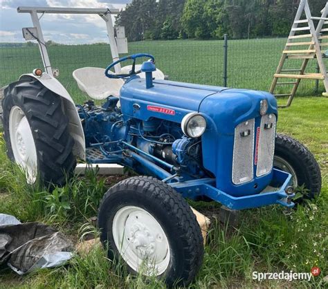 Ilustracja przedstawiająca ciągnik Ford 3000 w pracy polowej.