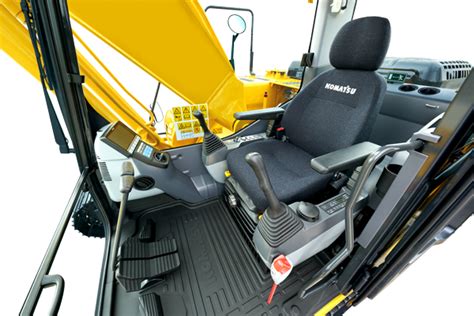 Detailed interior view of Komatsu PC210 operator's cabin, highlighting ergonomic controls