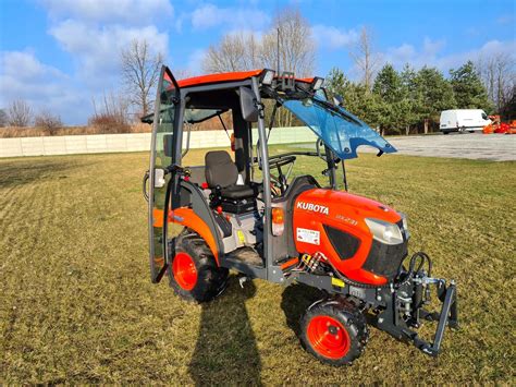 Zdjęcie miniciągnika Kubota BX231 z pługiem wirnikowym i piaskarką
