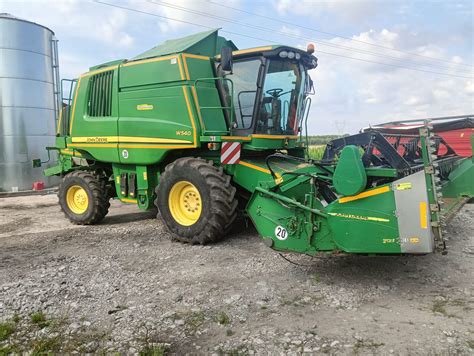 zdjęcie kombajnu John Deere W540i z zamontowanym hederem i sieczkarnią