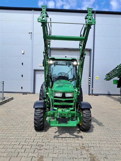 Kompaktowy ciągnik John Deere z ładowaczem czołowym w pracy komunalnej