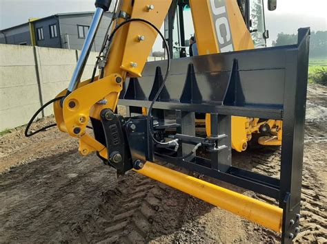 Thematyczne zdjęcie wideł do koparko-ładowarek JCB, ukazujące różne typy i ich zastosowanie