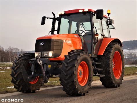 Kubota M128X na tle krajobrazu rolniczego
