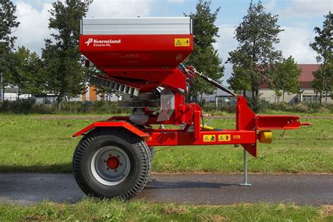 Rozsiewacz Kverneland pracujący na polu z ciągnikiem