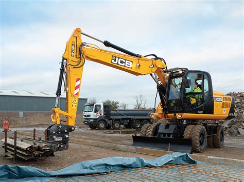 Zdjęcie wnętrza kabiny koparki JCB JS175W z widokiem na konsolę sterowniczą i fotel operatora.