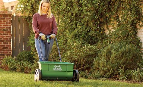 Thematic photo of a person using a garden spreader in a garden