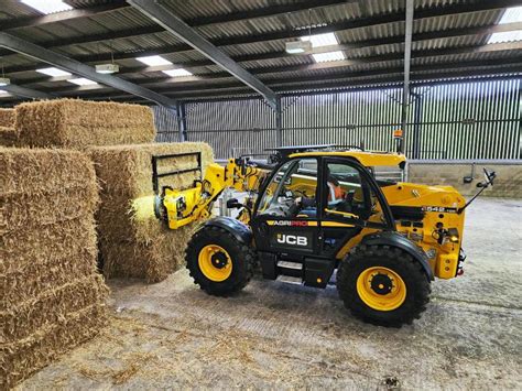 Zdjęcie ładowarki teleskopowej JCB 542-100 Loadall High Lift w akcji, demonstrujące jej maksymalną wysokość podnoszenia.