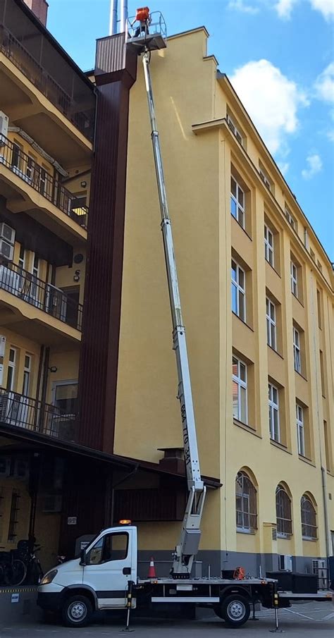 Zdjęcie podnośnika koszowego z operatorem na wysokości
