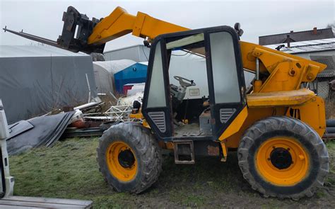 Zdjęcie ładowarki JCB z widocznymi oponami w trudnym terenie