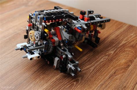 Infografika przedstawiająca złożony model LEGO Technic z elementami mechaniki