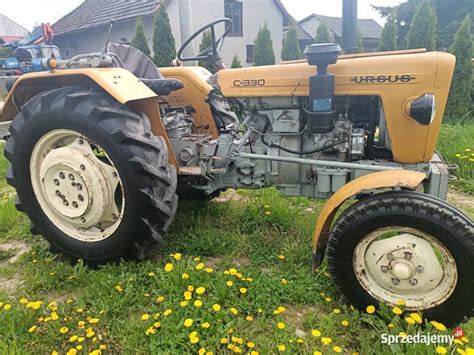 Zimny ciągnik Ursus C-330 na tle krajobrazu wiejskiego
