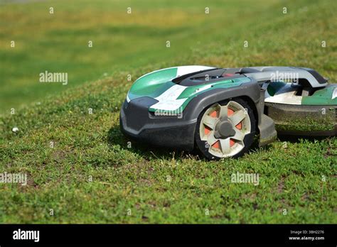 Photo of a robotic lawn mower working autonomously on a lawn