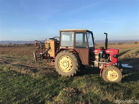 Ursus C-330 z zawieszonym opryskiwaczem rolniczym Pilmet Termit 303 podczas pracy w polu
