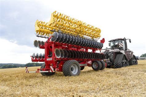 The Pöttinger Terradisc 10001 T disc harrow working in a field with deep ruts, pulled by a Steyr 6340 Terrus CVT tractor