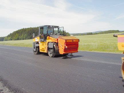 Rozrzutnik grysu Strassmayr BSWA zamontowany na walcu wibracyjnym podczas prac drogowych