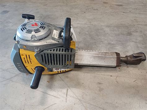 Wacker Neuson BH65 w akcji, rozbijanie betonu, mężczyzna w sprzęcie ochronnym