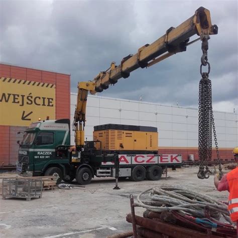 Tematyczne zdjęcie ciężarówki z rozłożonym hydraulicznym dźwigiem samochodowym podczas pracy